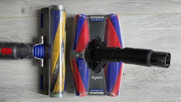 Zwei Dyson Staubsaugerbürsten nebeneinander auf hellem Holzboden.