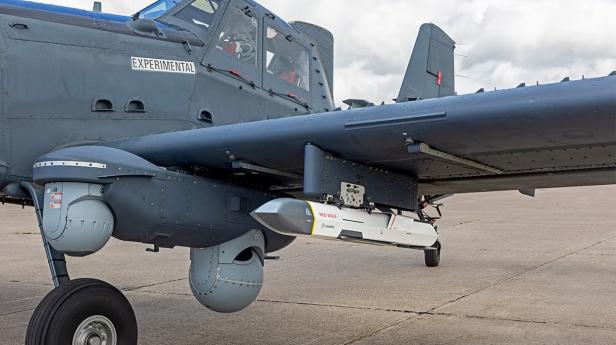 Flugzeug OA-1K steht am Rollfeld mit einer Rakete Red Wolf unter dem Flügel