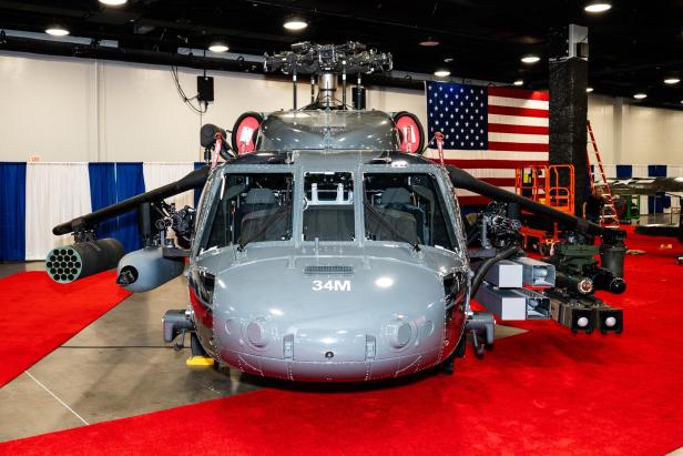 Kampfhubschrauber UH-60 Black Hawk mit montierten Waffen und Flügeln auf einer Messe ausgestellt.