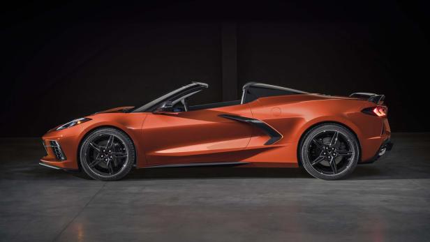 Corvette C8 in Orange steht vor schwarzem Hintergrund