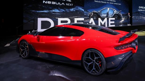 Ein roter Sportwagen ist bei einer Messe ausgestellt
