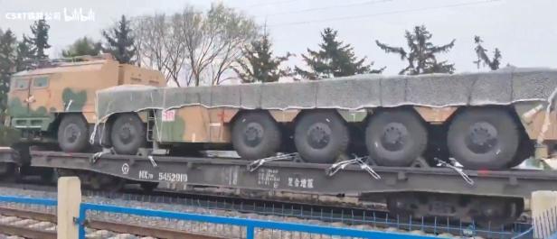 Militärischer Lkw auf einem Zug in heller Tarnfarbe
