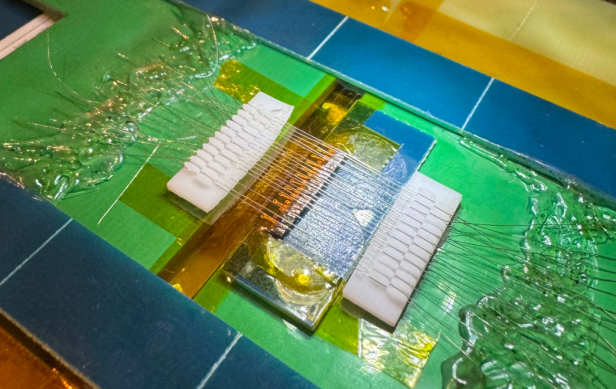 Nahaufnahme von einzeln verlöteten Drähten auf einer dünnen grünen Platine mit eInk-Display.