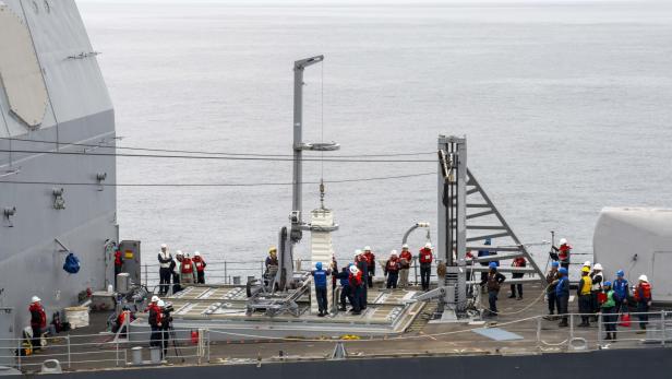 Eine Rakete wird in ein Kriegsschiff geladen