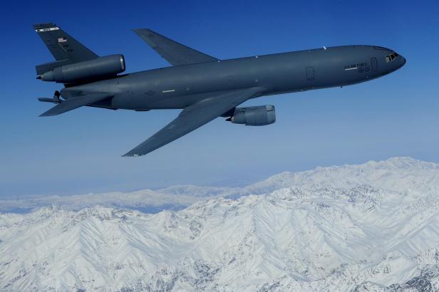 Ein Tankflugzeug fliegt über verschneite Berge