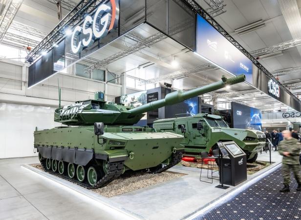 Ein Panzer steht auf einem Messestand bei einer Rüstungsmesse