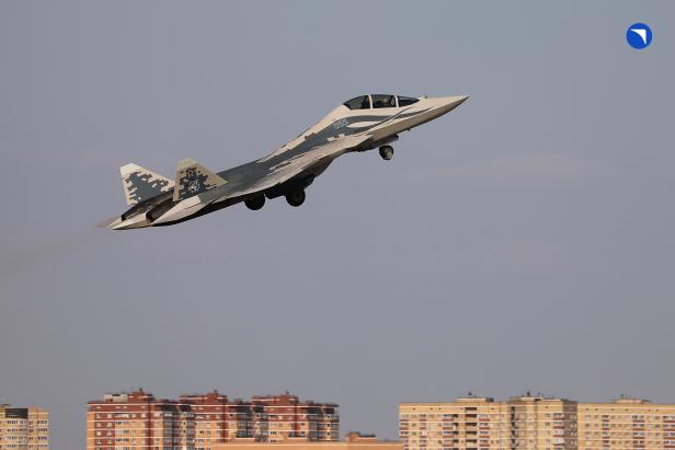 Kampfjet Su-57D startet, im Hintergrund sind Häuser zu sehen