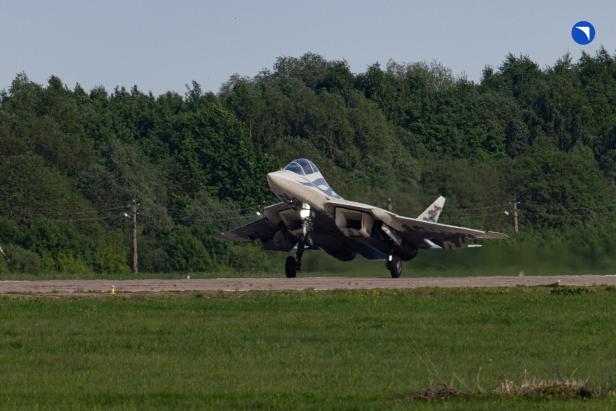 Kampfjet Su-57D landet, im Hintergrund sind Bäume