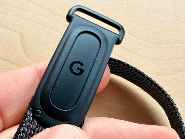 Nahaufnahme des Verschlusses eines schwarzen Fitbit Air Fitness-Armbands mit Google-Logo.