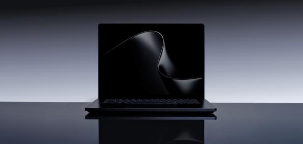 Ein schwarzes Notebook steht vor grauem Hintergrund