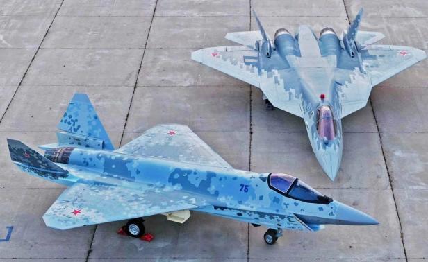Zwei Tarnkappen-Kampfjets mit digitaler Tarnlackierung stehen nebeneinander auf dem Rollfeld.