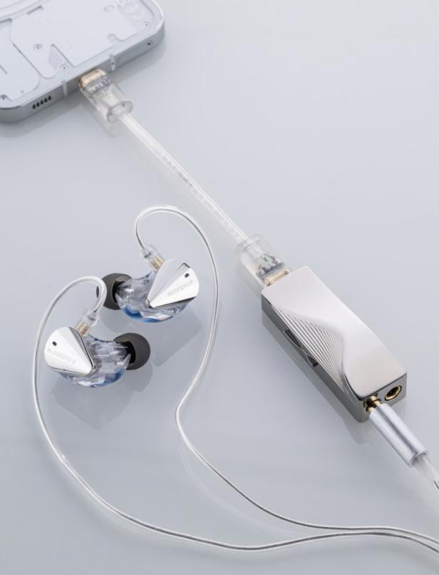 Silberne In-Ear-Kopfhörer mit durchsichtigem Kabel an Smartphone und tragbarem Verstärker angeschlossen.