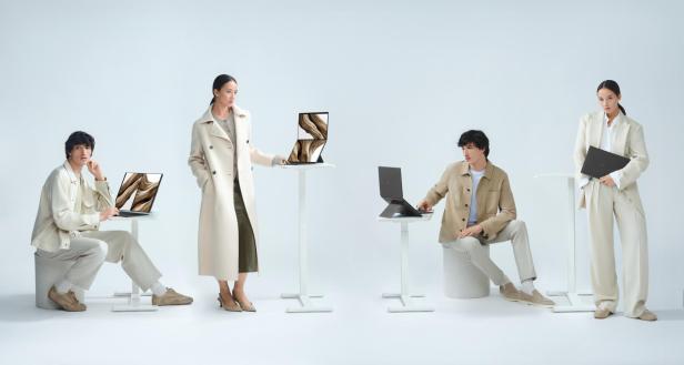 Vier Personen präsentieren verschiedene Nutzungsmodi eines Laptops mit zwei Bildschirmen.