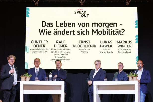 Sechs Männer stehen bei der Podiumsdiskussion „Das Leben von morgen – Wie ändert sich Mobilität?“ vor einer Leinwand mit ihren Namen und Funktionen.