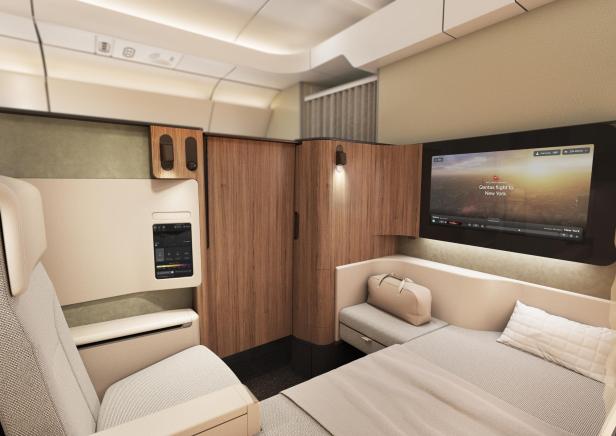 Luxuriöse Qantas-First-Class-Suite mit Bett und großem Bildschirm.