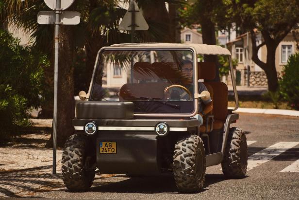 Elektrischer Buggy mit großen Reifen in einer sonnigen Resort-Straße.