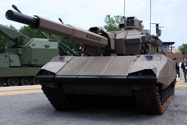 Ein beigefarbener KNDS-Panzer mit einem Ascalon 120-Geschütz steht auf einem Schotterplatz.