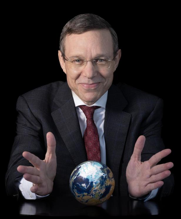 Ein Mann im Anzug vor einem schwarzen Hintergrund
