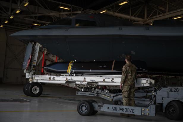 Ein Soldat steht vor einem B-2-Bomber in einem Hangar.