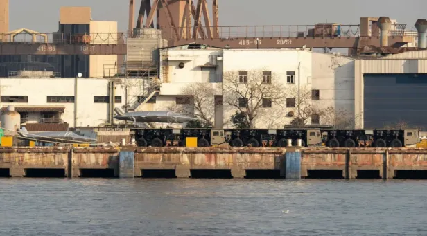 Mehrere gekoppelte Lkw mit einem modularen Katapult an einem Dock.