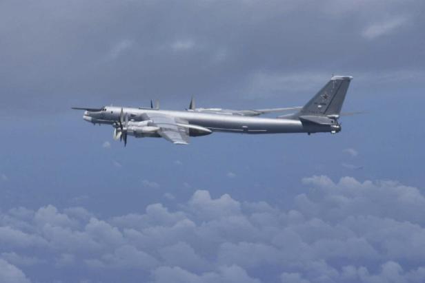 Russischer Bomber Tu-95 fliegt vor bewölktem Himmel