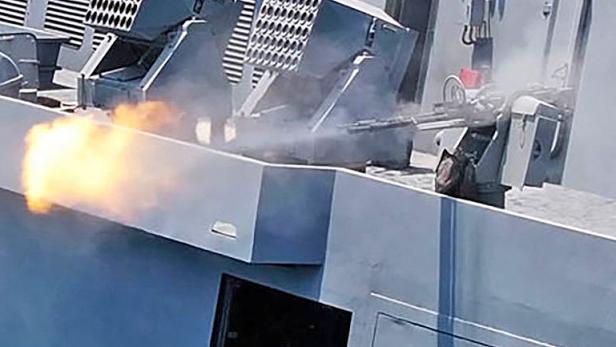 Ein Maschinengewehr auf einem Schiff schießt.