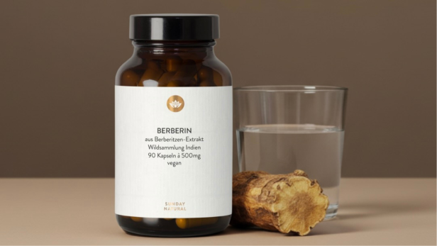 Berberin-Kapsel von Sunday Natural neben einem Glas Wasser und einer Berberitzenwurzel.
