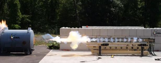 Railgun-Test auf einem Freigelände mit Feuerstoß und Rauch.