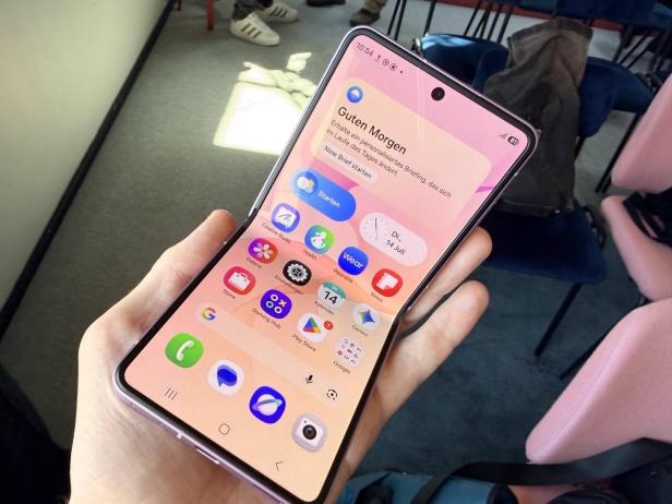 Person hält ein aufgeklapptes Samsung-Falthandy mit großem Display in der Hand.