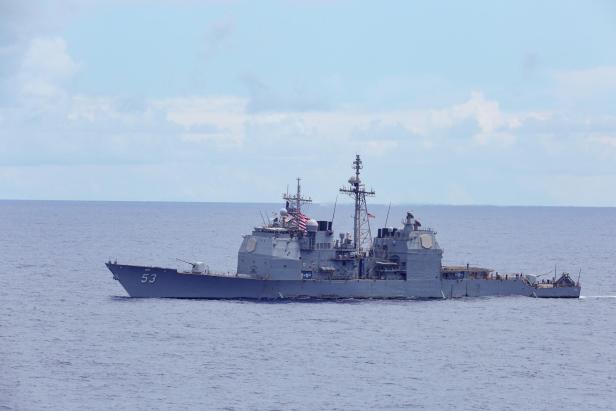 Graues Kriegsschiff fährt bei ruhiger See auf dem Meer