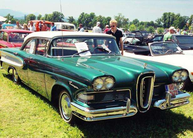 Ein grüner Ford Edsel steht auf einer Oldtimer-Ausstellung, umgeben von weiteren klassischen Autos und Besuchern.