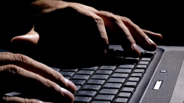 male hands on the keyboard,low key and high contrast,may suggest cyber cryme, hacking,spying