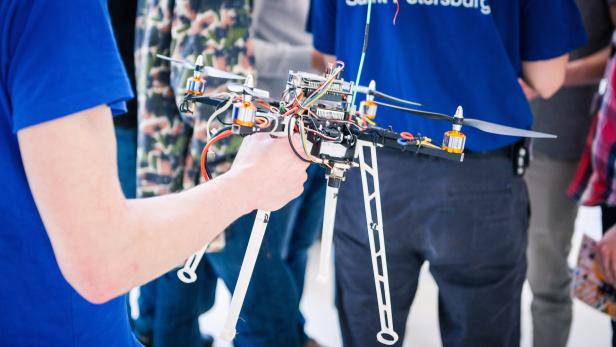 Eine Person hält eine selbstgebaute Drohne in der Hand.