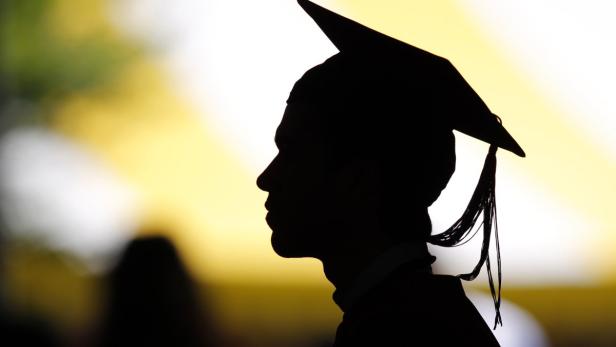 A view shows the silhouette of a student with a graduation cap as students take their seats for the diploma ceremony at the John F. Kennedy School of Government during the 361st Commencement Exercises at Harvard University in Cambridge, Massachusetts, in this May 24, 2012 file picture. With their remuneration levels and reputation under attack in the wake of the global financial crisis, investment banks are having to work harder to attract graduates. Gone are the big, brash corporate presentations, instead it&#039;s all about corporate responsibility, diversity and a long-lasting career. To match story BANKS/GRADUATES REUTERS/Brian Snyder/Files (UNITED STATES - Tags: EDUCATION)