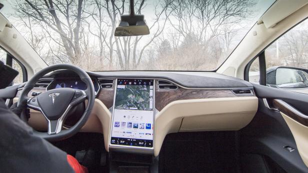 Innenansicht eines Tesla Model X mit Navigationssystem auf dem Bildschirm.