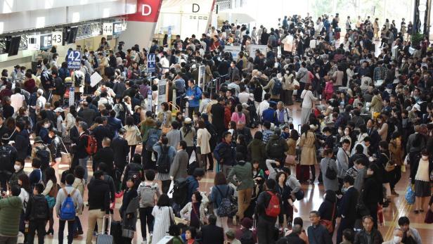 Hunderte Menschen warten am Haneda-Flughafen in Tokio auf ihre Flüge