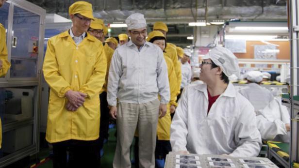 Apple CEO Tim Cook (li.) in einer iPhone-Produktionsstätte in China