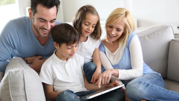 Family relaxing with kids and using digital tablet