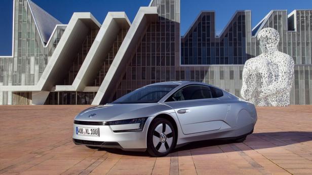 epa03593597 An undated handout photo provided by car manufacturer Volkswagen shows a VW XL1, two-seater sports car in front of a futuristic building as the car maker unveiled its long awaited one liter vehicle in Osnabrueck, Germany. Fifty of the vehichles are being built in Osnabrueck for lease to select clients. EPA/VW EDITORIAL USE ONLY/NO SALES