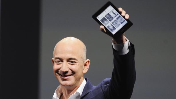 Amazon CEO Jeff Bezos holds up a Kindle Paperwhite during Amazon&#039;s Kindle Fire event in Santa Monica, California September 6, 2012. REUTERS/Gus Ruelas (UNITED STATES - Tags: SCIENCE TECHNOLOGY BUSINESS)