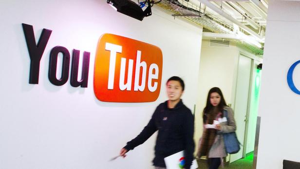 People walk by a YouTube sign at the new Google office in Toronto, in this November 13, 2012 file photo. A U.S. judge on May 15, 2013 denied class-action status to copyright owners suing Google Inc over the use of material posted on YouTube without their permission