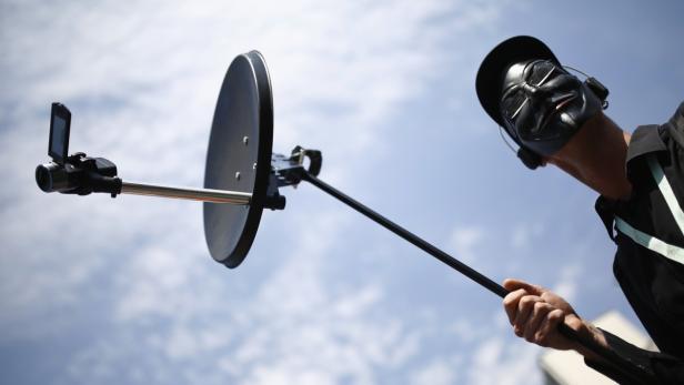 Ein Anti-NSA-Demonstrant zeigt eine stilisierte Abhörvorrichtung