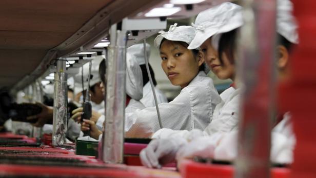 Workers are seen inside a Foxconn factory in the township of Longhua in the southern Guangdong province in this May 26, 2010 file photograph. Foxconn Technology Group, a major supplier of Apple Inc, said on August 22, 2012 it will further reducing overtime for its Chinese workers to less than 9 hours a week from the current 20. REUTERS/Bobby Yip/Files (CHINA - Tags: BUSINESS EMPLOYMENT SCIENCE TECHNOLOGY)