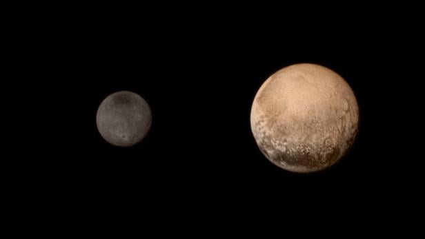 Ein Foto, auf dem sowohl Pluto als auch der größte Pluto-Mond Charon zu sehen sind.