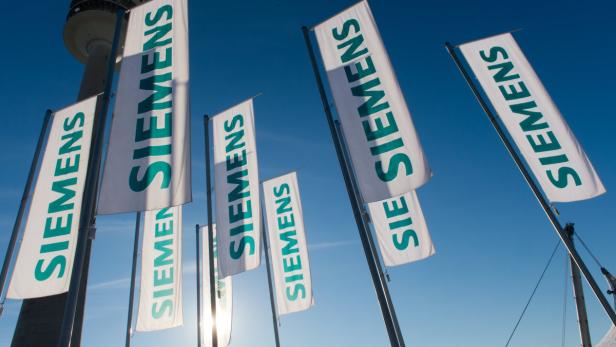 Siemens-Fahnen wehen am 23.01.2013 zur Siemens-Hauptversammlung 2012 in München (Bayern) vor blauem Himmel. Foto: Peter Kneffel/lby +++(c) dpa - Bildfunk+++