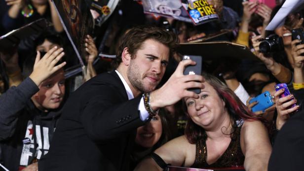 Der australische SchauspielerLiam Hemsworth (The Hunger Games) schießt es Selfie mit einem Fan