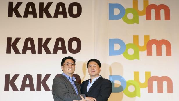 Daum CEO Choi Sae-hoon (li.) schüttelt die Hand von Kakao CEO Sirgoo Lee (re.)