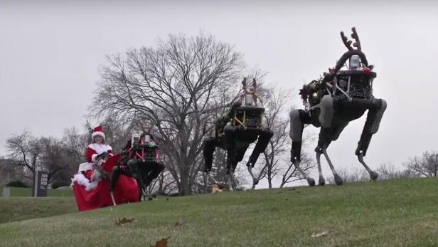 Als Rentiere verkleidete Spot-Roboter ziehen den Weihnachts-Schlitten