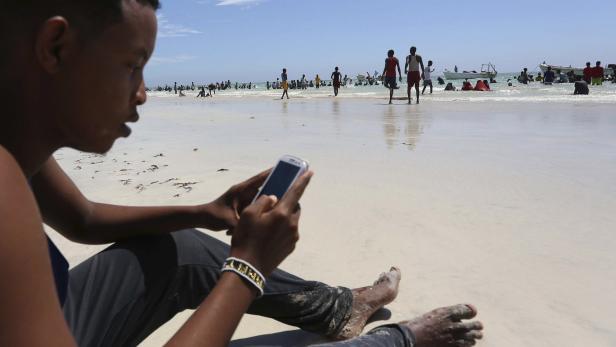 Ein junger Mann nutzt ein Smartphone in Mogadishu, der Hauptstadt von Somalia