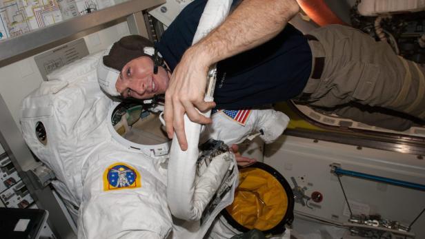 Astronaut Mike Hopkins untersucht seinen Raumanzug an Bord der Internationalen Raumstation (ISS).